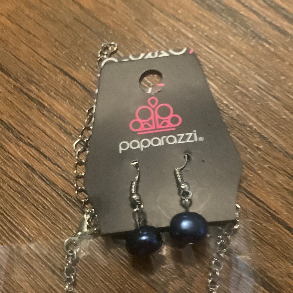 Long navy blue necklace on a silver chain with complimentary earrings.